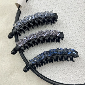 Close-up of three large banana hair clips with blue and purple gradient crystal beads