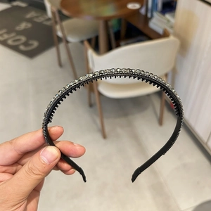 Close-up of black thin headband with crystal rhinestones and non-slip inner teeth