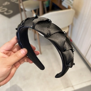 Detailed view of hand-stitched black crystal headband with elegant vintage beaded texture