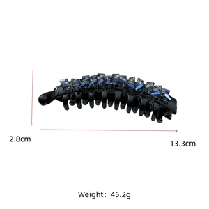 Detailed view of black banana hair clip with blue crystals and size measurement labels