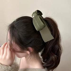 Olive green knitted bow banana clip shown in a high ponytail hairstyle detail view
