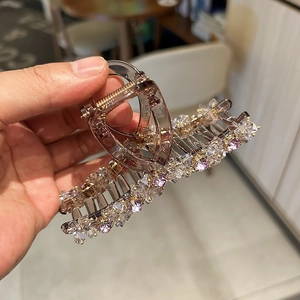 Close-up of large crystal hair claw clip with purple rhinestones and coffee frame
