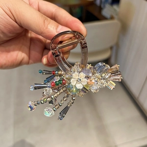 Elegant Korean hair claw clip with colorful crystals and white flower on amber base