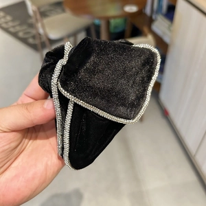 Close-up of black velvet hair scrunchie with sparkling rhinestone trim detail