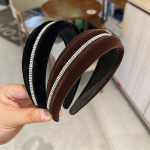 Detailed close-up of velvet headband with sparkling rhinestone inlay in black and brown