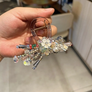 Elegant crystal shark hair claw with white flower and beads on transparent resin base