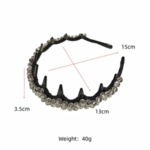Detail of punk style headband with clear crystals and black cone spikes on white background