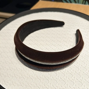 Close-up detail of a brown velvet headband with sparkling rhinestones on the band