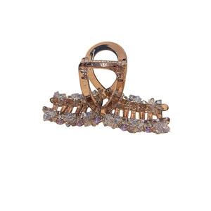 Elegant rose gold hair claw clip with purple gems and sparkling crystals on white background
