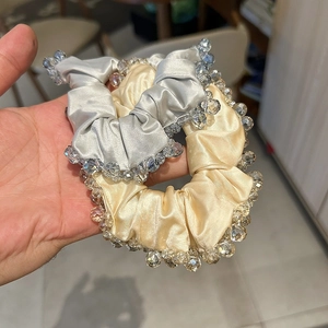 Detailed macro view of satin scrunchies with sparkling crystal beaded edges