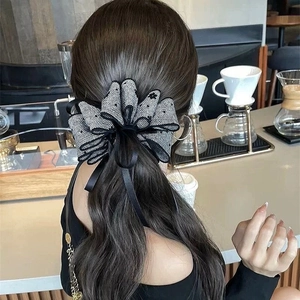 Detail view of multi-layer mesh bow hair clip with black and white polka dots