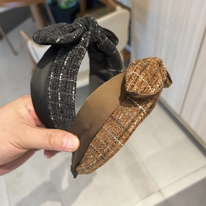 Close-up of tweed knotted headband with woven texture and sparkling thread details