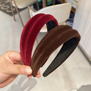 Close-up of velvet padded headbands in burgundy and dark brown with soft fabric texture