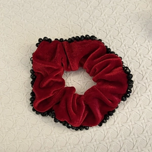 Vue détaillée du chouchou en velours rouge foncé avec d'élégantes perles noires