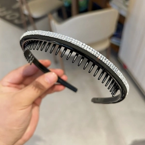 Détail d'un serre-tête antidérapant avec trois rangées de strass argentés et dents internes