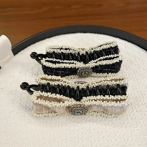 Detailed close-up of bow banana clips with pearl edges and rhinestone accents