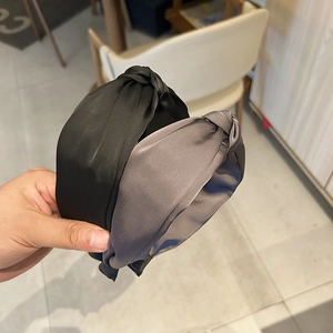 Détail de serre-têtes noués en satin de soie noir et gris avec une texture de tissu large