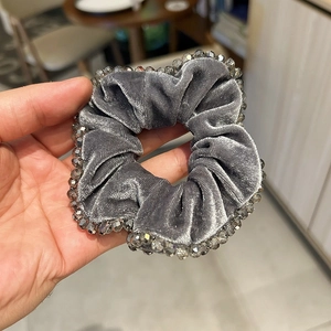 Détail d'un chouchou en velours gris avec perles de cristal et plis élégants