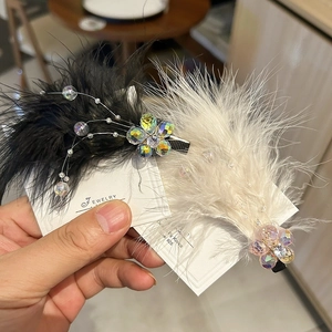 Detailed macro view of white and black feather hair clips with colorful crystal beads