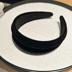 Detailed view of black velvet padded headband texture on a white woven tray display