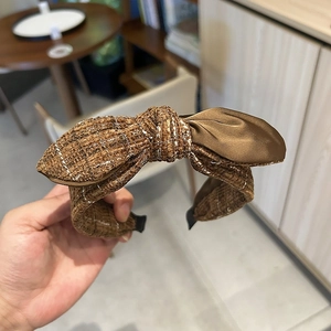 Detail of dark brown tweed and satin bow headband with protective end caps