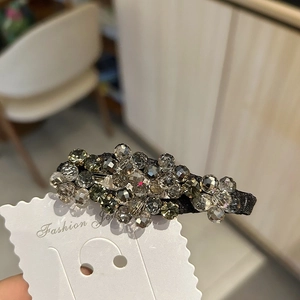 Elegante fermaglio per capelli con perline di cristallo grigio fumo su carta bianca