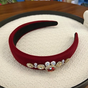 Close-up of burgundy velvet headband featuring luxury crystal gems and white pearls