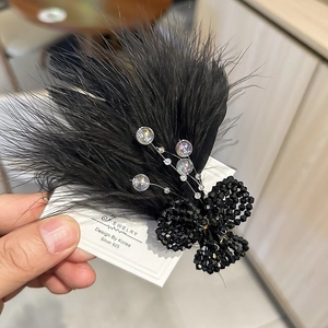 Detail of luxury black feather hair clip with crystal flowers and beaded accents