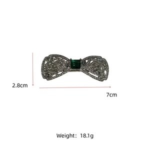 Barrette à cheveux nœud argenté avec gemme émeraude montrant les dimensions 7cm x 2.8cm