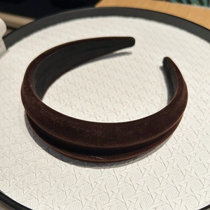 Detail view of the plush brown velvet fabric texture on a wide padded headband