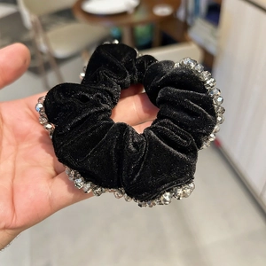 Détail d'un chouchou en velours noir orné de perles de cristal brillantes et douces
