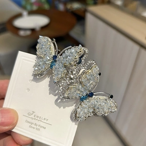 Elegant silver butterfly hair clip with blue gemstones and white crystals inlay