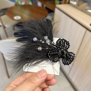 Macro shot of black feather hair clip with beaded floral detail on S925 silver base