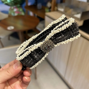 Detailed view of elegant black tweed banana hair clip with white beads and gemstone