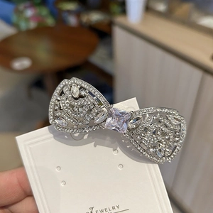 Pince à cheveux nœud argentée luxueuse ornée de diamants brillants et cristal central