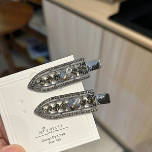 Detail of gun-metal hair clips with grey rhinestones and butterfly crystal charms