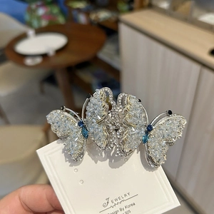 Detail of silver alloy butterfly hair clip with blue gems and white crystals