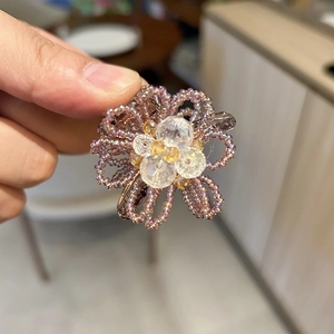 Detailed view of hand-held luxury purple beaded flower hair claw with crystal tassels