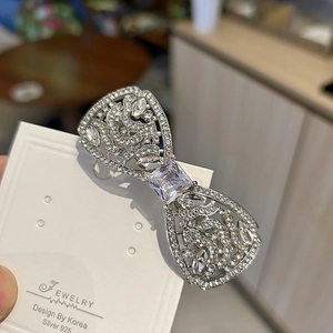 Détail de la barrette à cheveux nœud argenté avec strass brillants et pierre centrale carrée
