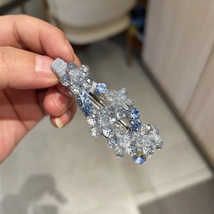 Dettaglio di fermaglio per capelli in cristallo con perline blu e base in tessuto