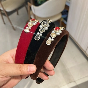 Close-up of three velvet headbands with inlaid crystals and pearls in luxury style