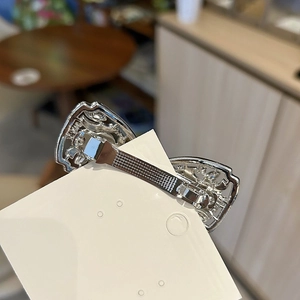 Barrette à cheveux élégante en métal argenté ajouré sur une carte de produit blanche