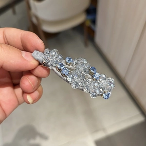 Dettaglio di un fermaglio per capelli con perline di cristallo azzurro e base argento