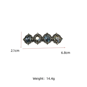 Detail view of a 6.8cm vintage crystal hair clip with blue and brown stones and silver lace