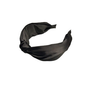 Serre-tête en satin noir classique avec large nœud torsadé sur un fond blanc pur