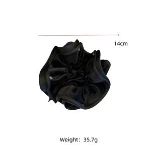 Detail of black velvet scrunchie with sparkling rhinestones and 14cm diameter size