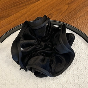 Elegant black velvet lace scrunchie with silver rhinestones on a white textured tray