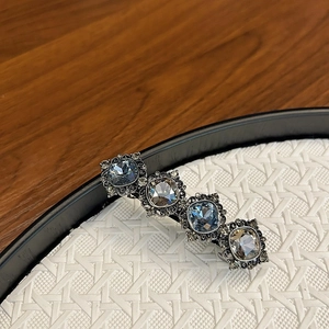 Vintage silver hair clip with sea blue and champagne square crystals on a textured tray