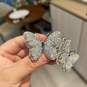 Elegant silver butterfly hair clip with blue crystals and sparkling rhinestones