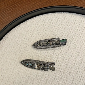 Macro detail of luxury rhinestone hair clips with floral crystal inlays on metal base
